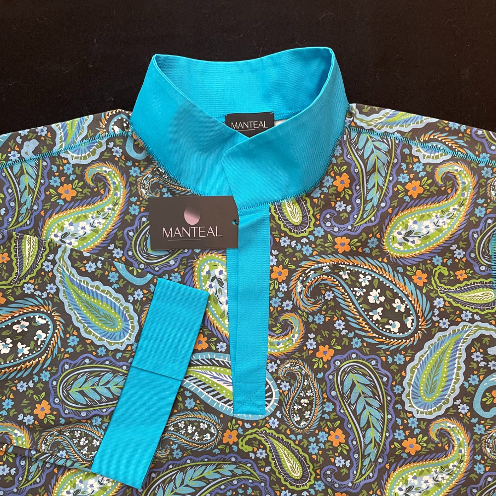 A patterned fabric nightshirt, with turquoise collar and placket, showing a Manteal label.